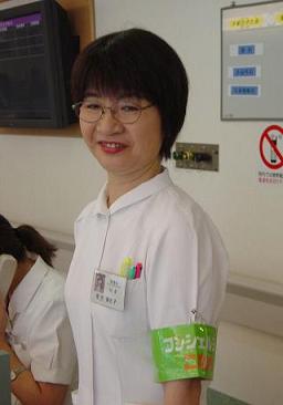 病院コンシェルジュとして、総合案内デスクの脇に立つ看護科課長の菊池美佐子さん。