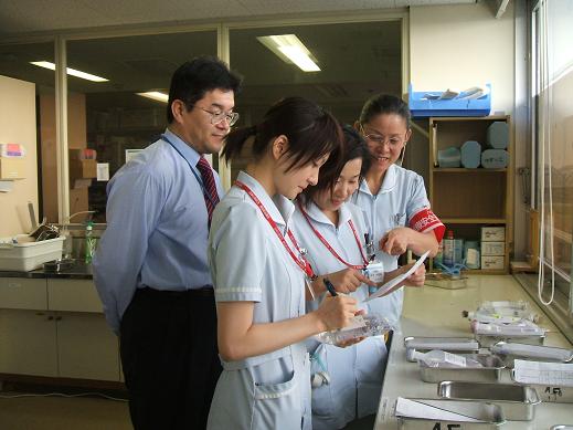 写真＝現場に出向いて手順の確認（足立さん＝左端と川崎さん＝右端）